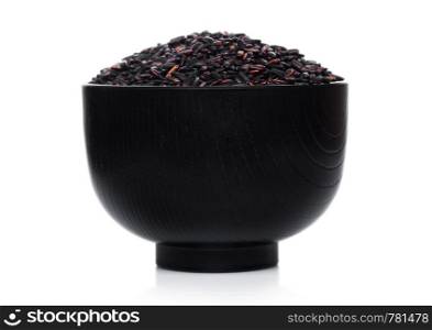 Black bowl of raw organic black venus rice on white background.