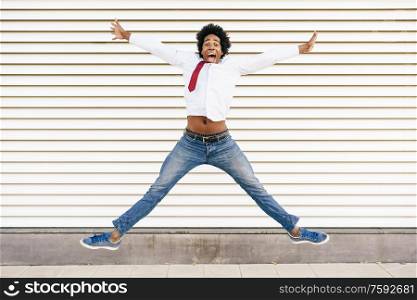 Black Businessman jumping outdoors. Happy Man with afro hair.. Black Businessman jumping outdoors. Man with afro hair.