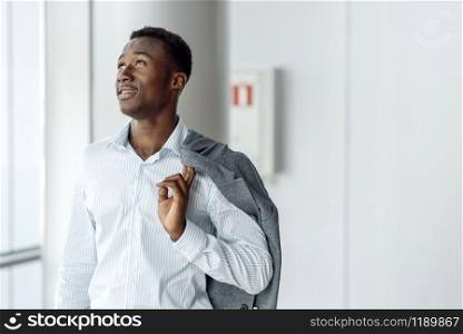 Black businessman poses in office building. Successful business person, black man in formal wear, shopping center. Black businessman poses in office building