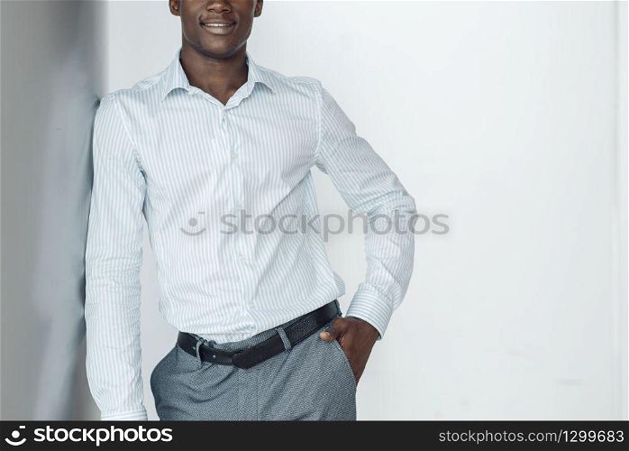 Black businessman poses in office building. Successful business person, black man in formal wear, shopping center. Black businessman poses in office building