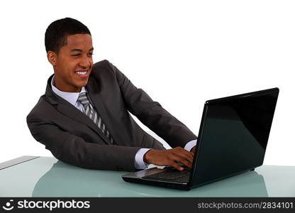 Black businessman sat with laptop