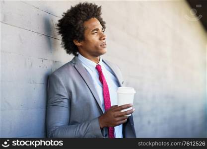 Black Businessman taking a coffee break with a take-away glass. Man with afro hair.. Black Businessman taking a coffee break with a take-away glass