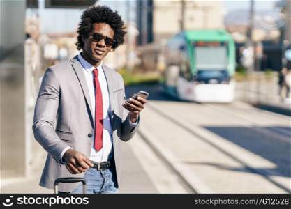 Black Businessman waiting for the next train. Man with afro hair commuting.. Black Businessman waiting for the next train