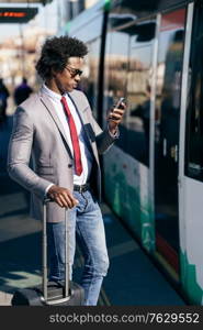 Black Businessman waiting for the next train. Man with afro hair commuting.. Black Businessman waiting for the next train