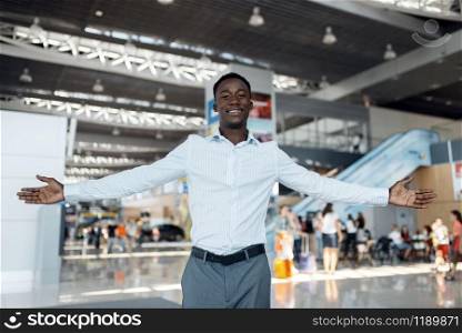 Black businessman welcomes the guests car showroom. Successful business person on motor show, black man in formal wear. Black businessman welcomes guests, car showroom