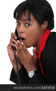 black businesswoman on the phone shocked at sensational news