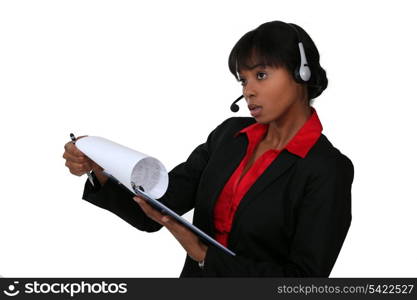 black businesswoman with headset holding clipboard