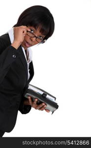black businesswoman with lowered glasses holding agenda