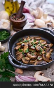 black ceramic bowl with fried mushrooms on grey concrete background.. black ceramic bowl with fried mushrooms on grey concrete background