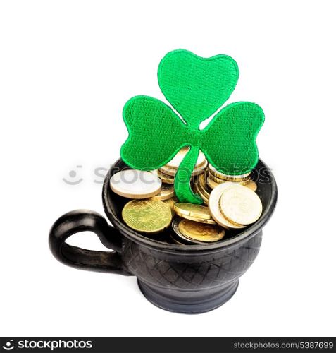 Black ceramic pot with golden coins and shamrock isolated on white. St. Patrick Day concept