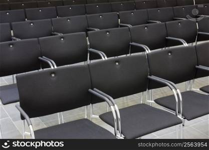 Black chairs of a lecture hall in a row