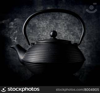 Black chinese teapot on a black background