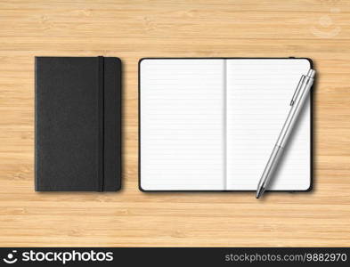 Black closed and open lined notebooks with a pen. Mockup isolated on wooden background. Black closed and open lined notebooks with a pen on wooden background