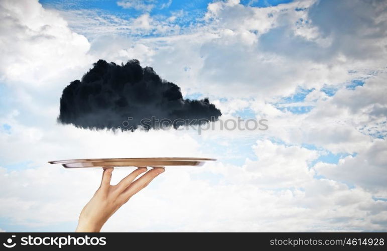 Black cloud on tray. Human hand holding metal tray with black cloud