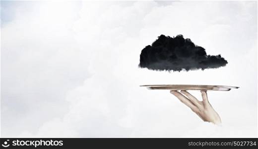 Black cloud on tray. Human hand holding metal tray with black cloud