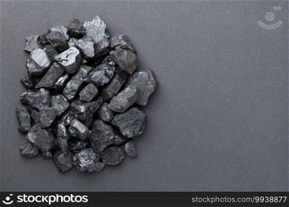 Black coal pile over graphite background. Copy space. Top view