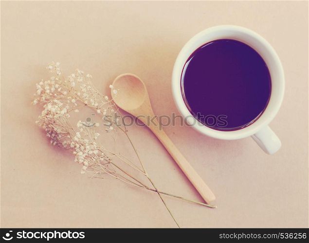 Black coffee and spoon with dried flower, retro filter effect