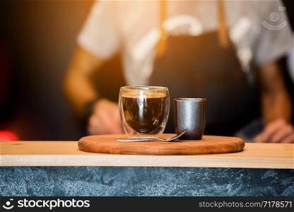 Black Coffee Cup On Wooden Table And Coffee Barista ..Horizontal.Blurred Background.Film effect.