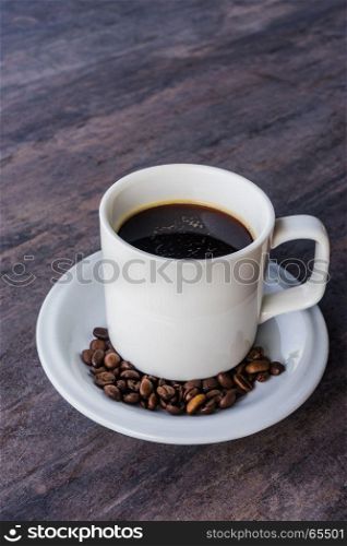 Black Coffee in a white cup set and coffee been on the gray wooden table with copy space