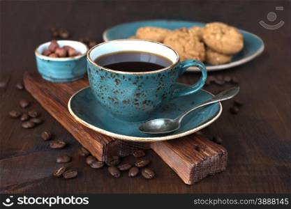 Black coffee in blue vintage cup on old dark cutting board
