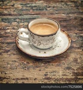 Black coffee on wooden table. Vintage style still life. Retro toned picture