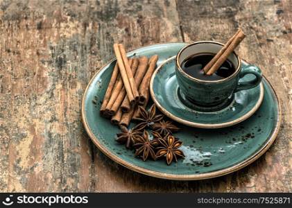 Black coffee with cinnamon and star anise spices. Vintage style still life