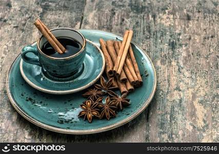 Black coffee with cinnamon and star anise spices. Vintage style toned picture