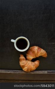 black coffee with croissant . black coffee with croissant at board