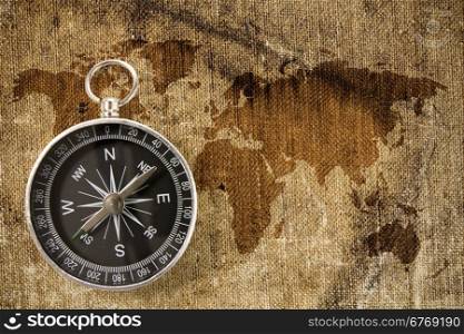 Black compass on the grunge map of world