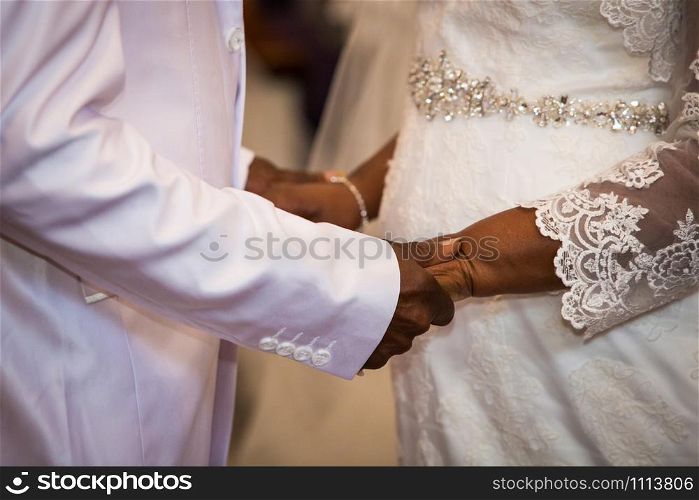 black couple holding hands during marriage ceremony. black couple holding hands during marriage