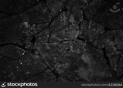 Black cracked concrete texture closeup background.