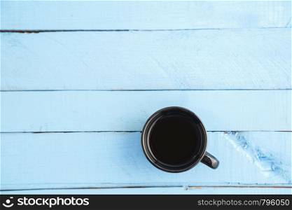 black Cup with drink on blue wooden background. the view from the top