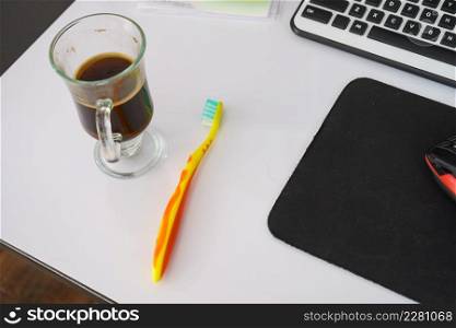 Black dark espresso coffee and toothbrush on table. Drinks impact on teeth health.. Black dark espresso coffee and toothbrush on table
