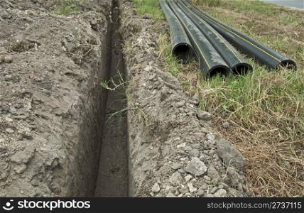 Black deep plastic pipes and ditch.
