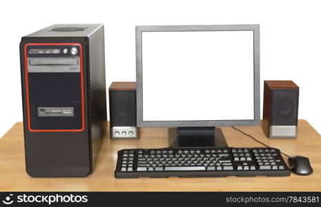 black desktop computer, display with cutout screen, keyboard, mouse, speakers on wooden table isolated on white background