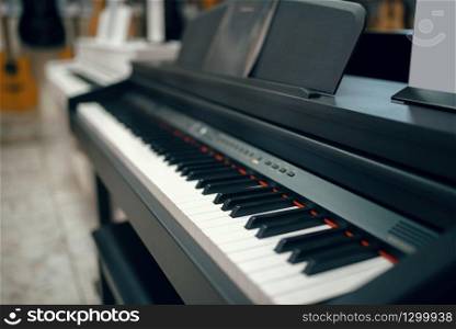 Black digital piano in music store, closeup view on keyboard, nobody. Assortment in musical instrument shop, professional equipment for musicians and performers