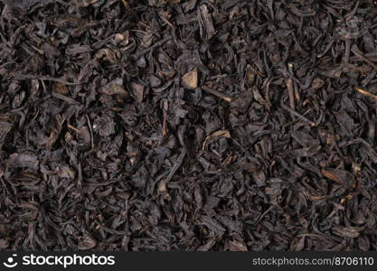 Black dried tea as a natural background. Close up top view. 