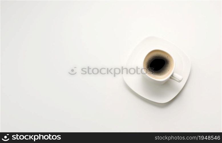 black espresso coffee in white ceramic cup with saucer on white table, top view, copy space