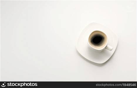 black espresso coffee in white ceramic cup with saucer on white table, top view, copy space