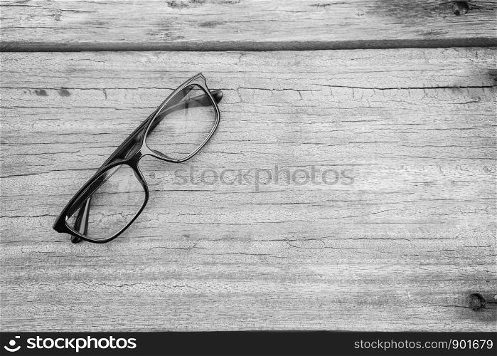 Black eye glasses spectacles with shiny black frame For reading daily life To a person with visual impairment. Wood background as background health concept with copy space.