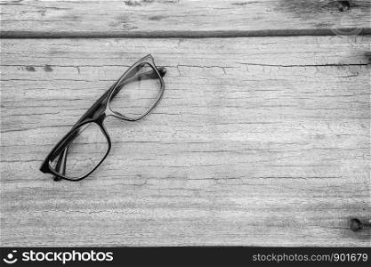 Black eye glasses spectacles with shiny black frame For reading daily life To a person with visual impairment. Wood background as background health concept with copy space.