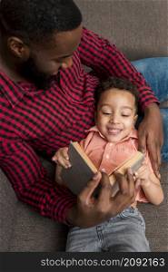 black father cute son reading book couch