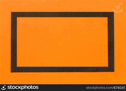 Black flat paper frame on orange background Halloween Layout for a design Mock up. Black paper frame on bright orange background