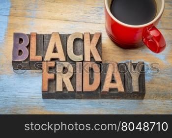 Black Friday banner in vintage letterpress wood type blocks stained by color inks with a cup of coffee