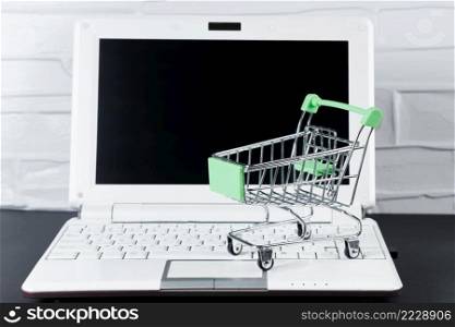 Black Friday concept. Mini shopping cart and laptop. Online sale and discounts.. Black Friday concept. Mini shopping cart and laptop. Online sale and discount.