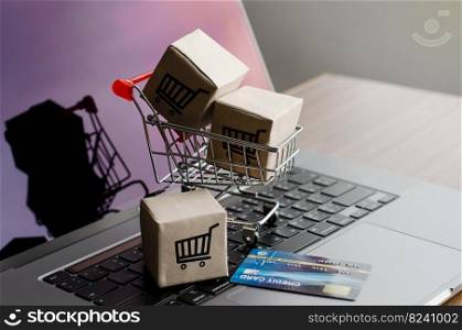 Black Friday online shopping Cardboard boxes or parcels with shopping cart and credit card logos on the keyboard. Home delivery service during the holidays