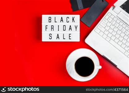 Black Friday sale concept. Laptop and coffee cup on a red background. Banner for advertising.. Black Friday sale concept. Laptop and coffee cup on red background. Banner for advertising.
