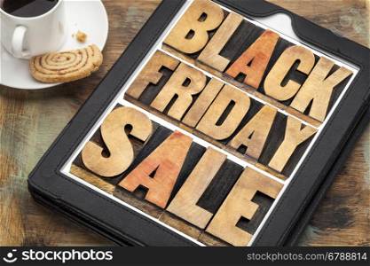 Black Friday sale - holiday shopping concept -word abstract in letterpress wood type on a digital tablet with a cup of coffee