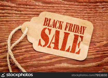 Black Friday sale sign a paper price tag against rustic red painted barn wood