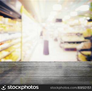 black granite table top and blur of supermarket with miscellaneous product on shelves